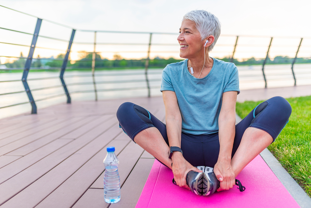 A senior woman does yoga outside